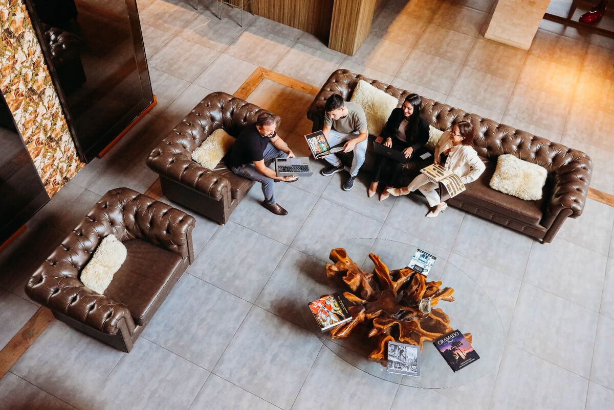 Equipe comercial de hotel analisando dados no lobby